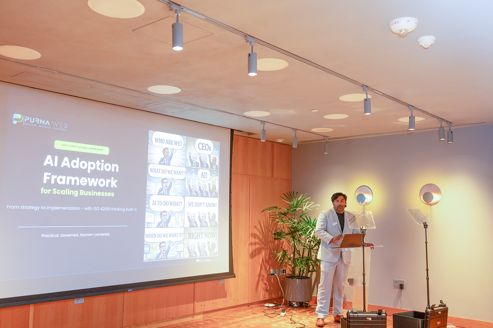 Hridin Chandrasekharan presenting the AI Adoption Framework for Scaling Businesses, with a slide noting ISO 42001 thinking built in, at Toronto Tech Week.